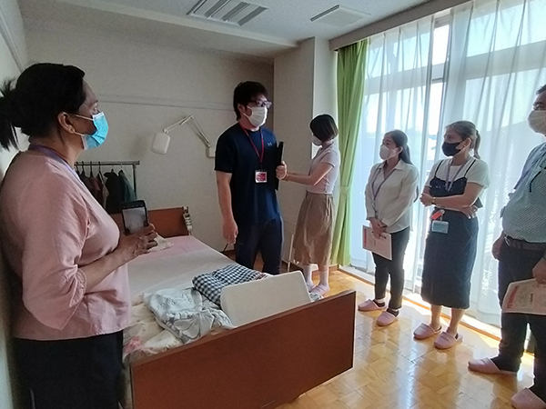 Training participants lined up to listen to the care staff's explanation