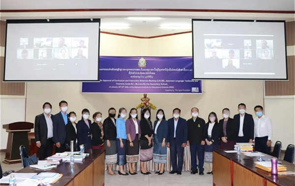 大きなスクリーンが2つ吊り下げられた会場正面に16名ほどの参加者が横に並んでいる。