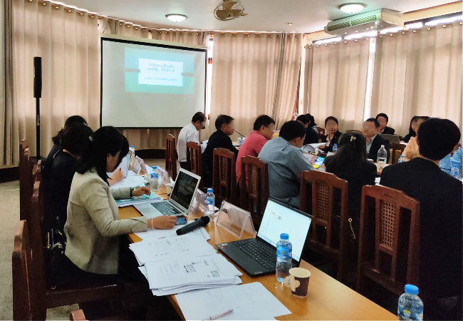 カーテンが引かれ、スクリーンに資料が投影されている会場の様子。