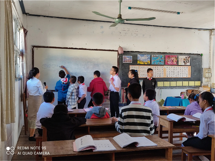 生徒たちが教室前方のホワイトボードの前に並んで数字を書いている。