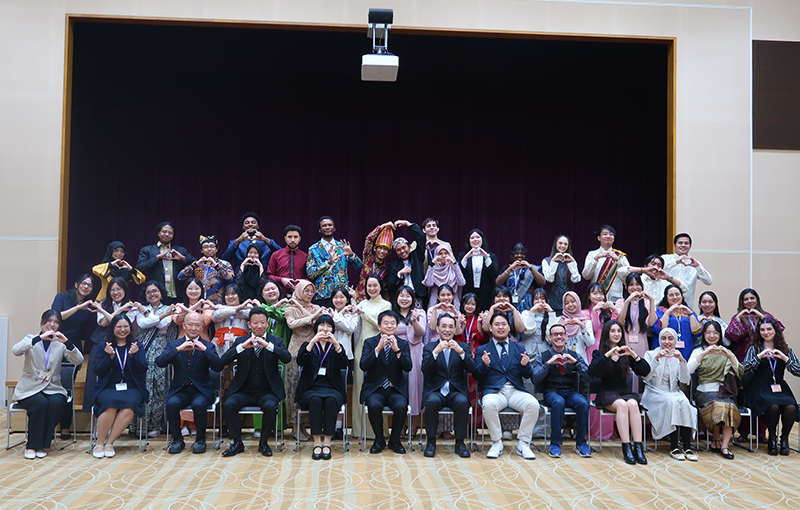 基礎研修修了式にて、約50人が写っている集合写真。手でハートをつくっている。