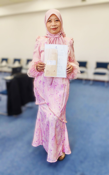 今回の修了式でスピーチをしたレハナさん。屋内にて、国際交流基金から送られた書類を持って立っている。