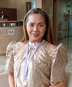 ミラさんのポートレイト　メダルを首から下げた、長髪の女性