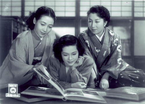 映画『西陣の姉妹』のシーン 登場人物女性3人が一緒に本を見ている場面