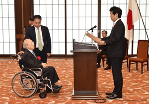薗浦健太郎外務副大臣（当時）(右)より表彰状を受け取る会長の福原義春（当時）の写真