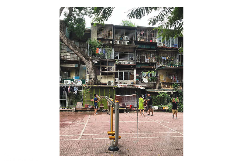 4回ほどの高さのある建物に囲まれた中庭でネットを張って人々がボールゲームをしている