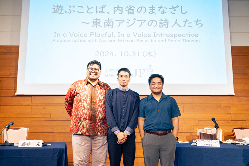 Photo of Norman (left), Fujii (center), and Paolo (right) on stage